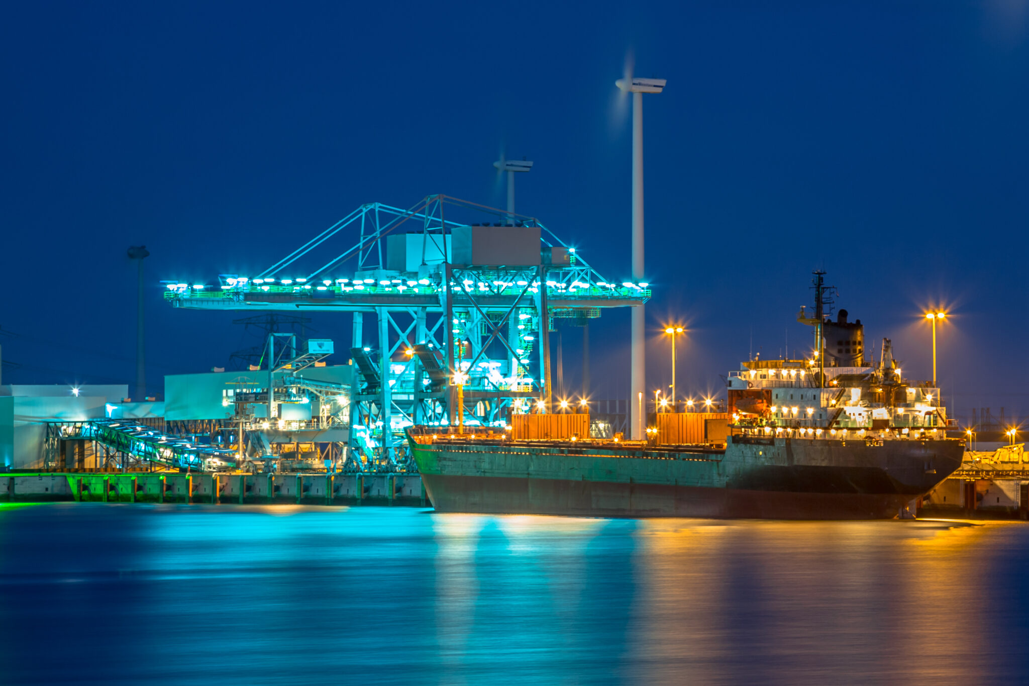 Freight ship moored at a harbour quay at night